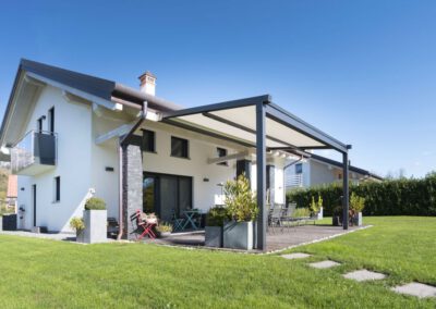 Wall-mounted pergola solution with cover for a house with a garden