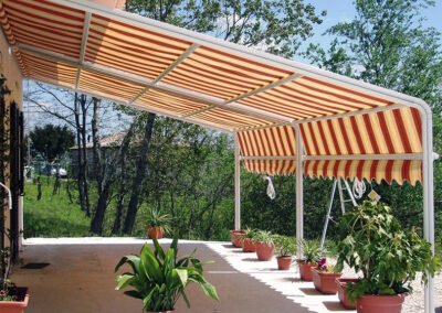 soluzione fissa appoggiata al muro con tenda da sole per terrazzo con giardino